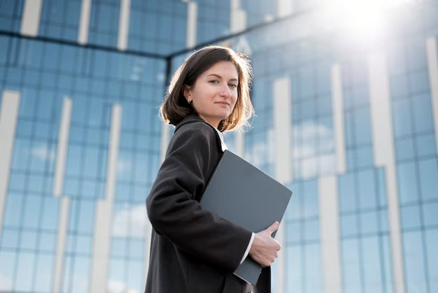 Woman in a suit holding a folder.