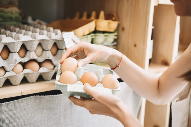 Woman purchasing eggs with an egg carton box