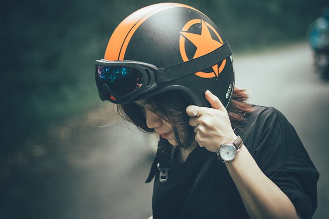 A woman wearing a helmet on a motorcycle