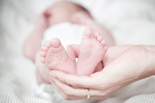 Adult holding baby's feet