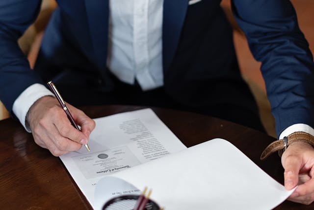 A man in a suit signing a document, representing Scott's Law